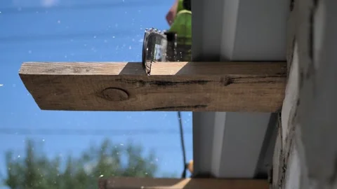 A chainsaw cuts a board in the process of roofing. There is no face, sawdust is Stock Footage 247892468