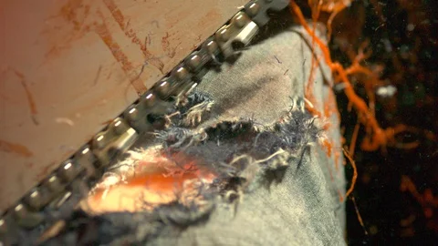 Chainsaw cutting through jeans, red oozing out Stock Footage 127943904