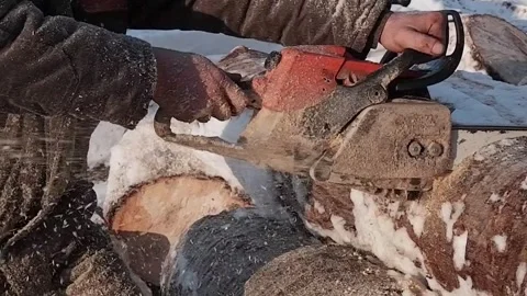 A chainsaw in the hands of a worker who saws a log into pieces. Close-up. Stock Footage 170850466