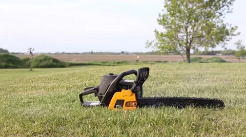 Chainsaw idling in grass Stock Footage 64221836