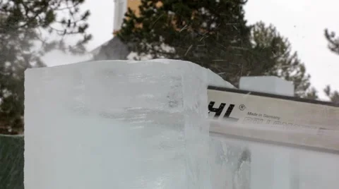 Chainsaw sawing a large ice cube for ice sculpting in Finland Stock Footage 51581593