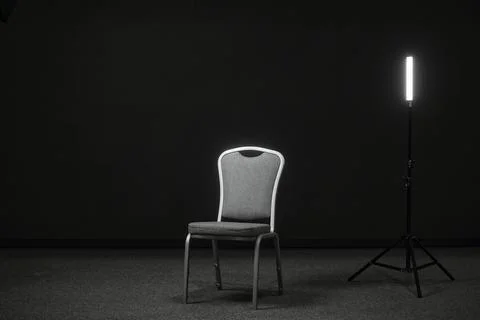 A chair and a light source on the stage for recording an interview or blog Stock Photos