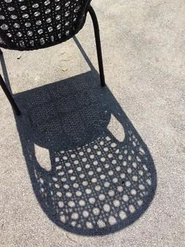 Chair Casting Shadow on Rough Concrete Surface Stock Photos