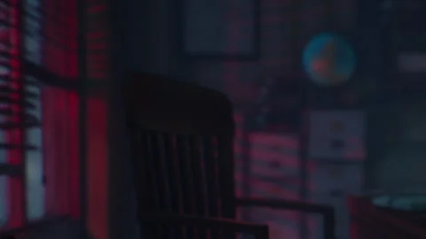 Chair in a dark room with red light coming through the window at night Stock Footage 344990325