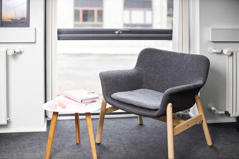 A chair sitting in front of a window Stock Photos