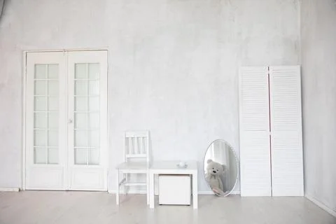 Chair, table and mirror in the interior of an white room with a door Stock Photos