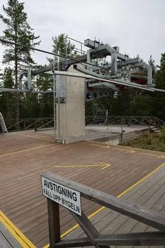 Chairlift exit sign reading "Exit  Raise Safety Bar" at a mountain lift stati Stock Photos