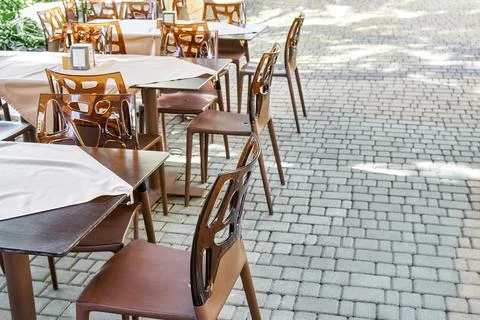 Chairs and empty tables in open air restaurant in summer 写真素材