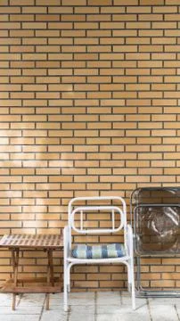 Chairs and table in front of a brick wall. Stock Photos