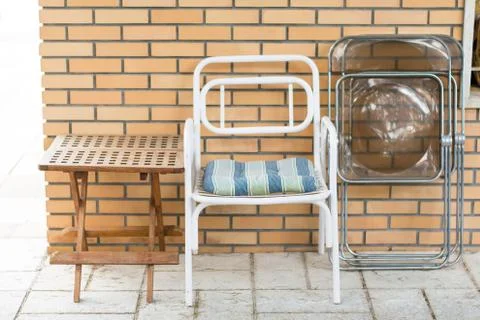 Chairs and table in front of a brick wall. Stock Photos