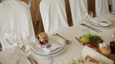 The chairs and table for guests, decorated with candles, served with cutlery and Stock Footage 65957009