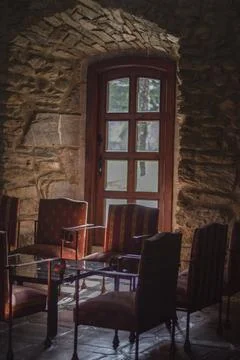 Chairs and a table stand by the window in the castle Stock Photos