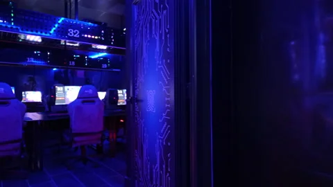 Chairs and tables with computers in row inside of internet cafe Stock Footage 153992972