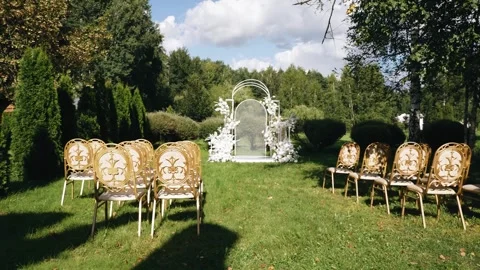 The chairs are lined up in neat rows in front of a festive outdoor arch Stock Footage 302111551