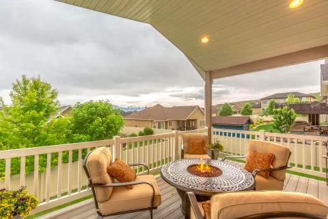 Chairs around table with fire pit at a residential balcony framed with railings Stock Photos