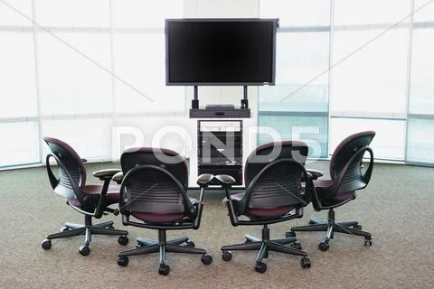 Chairs arranged around big screen TV Stock Photos