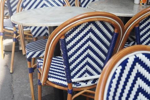 Chairs with blue and white patterns outside a cafe during daylight hours Stock Photos