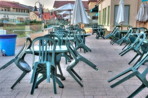 Chairs leaning on the tables. Stock Photos