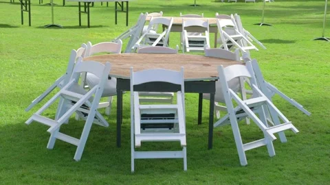 Chairs placed around a round table on the grass in the garden in 4k slow mo.. Stockbeeldmateriaal 279445125
