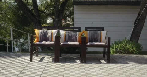 The chairs stand against the background of a white wooden house and trees Video stock 306331208