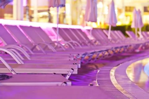Chaise-longues by the pool in the evening Stock Photos