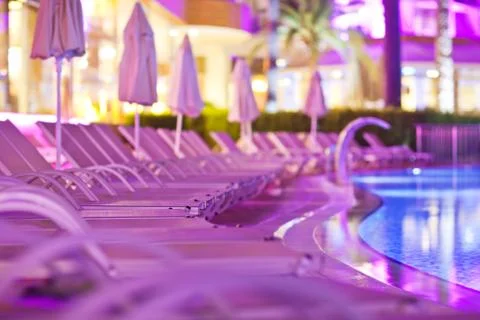 Chaise-longues by the pool in the evening Stock Photos