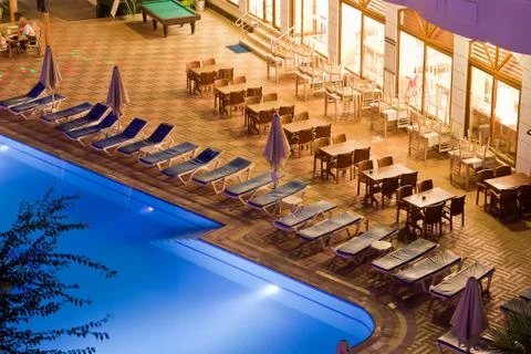 Chaise-longues by the pool in the evening Stock Photos