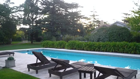 Chaise Lounge Chairs On Poolside At Vacation Villa. panning shot Stock Footage 256017803