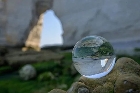 Chalk cliffs of Etretat seen through glass sphere Stock Photos