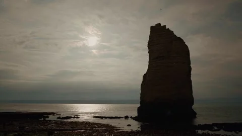 Chalk cliffs growing out of the sea and reflection of the sun on the sea water Stock Footage 299650422