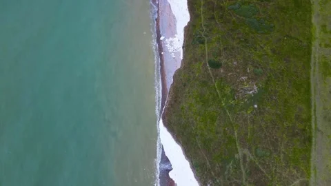 Chalk cliffs with sea below and waves crashing against the shore East Sussex, UK Stock Footage 246410971