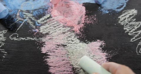 Chalk drawing on dark surface with hand creating colorful art Stock Footage 341273053