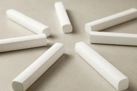 Chalk pieces arranged in a circular pattern on a neutral background Stock Photos