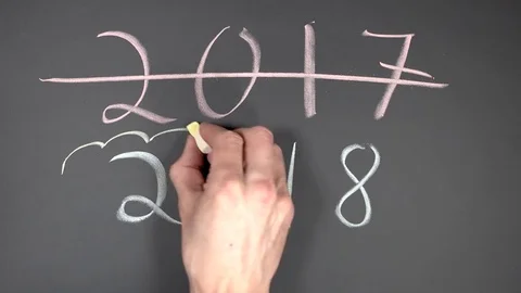 Chalk writing - erasing 2017 and writing 2018 on chalkboard Stock Footage 84010344