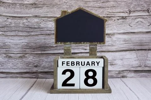 Chalkboard with date on white cube block on wooden table. Foto stock