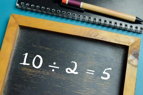 Chalkboard with phrase 10  2 = 5 math equation on wooden desk Stock Photos