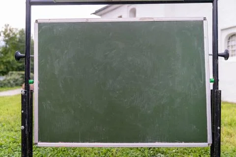 A chalkboard is positioned on grass, covered in scribbles and marks Foto stock