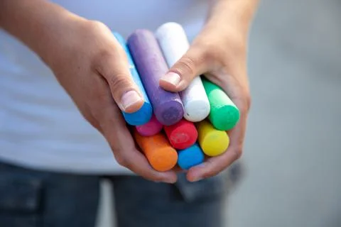 Chalks. Large multi-colored crayons in children's hands. The child holds the  Stock Photos