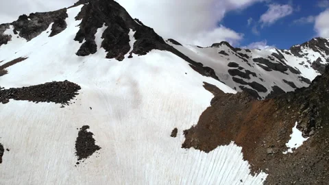 Challenging ascent through textured ice patches toward frosty mountain summit Stock Footage 321452086
