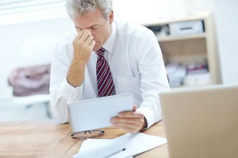 Challenging work causing problems. Stressed businessman sitting at an office Foto stock