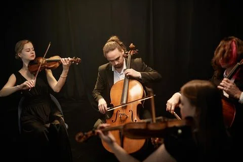 Chamber String Ensemble Performing on Black Background Stock Photos