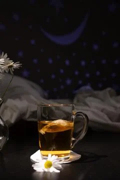 Chamomile Tea Beside a Soft Bed as Night Light Shines Softly During Bedtime Stock Photos