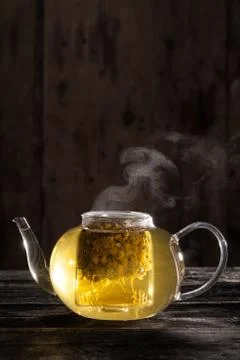 Chamomile tea in a clear teapot Stock Photos