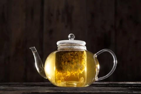 Chamomile tea in a clear teapot Stock Photos