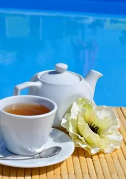 Chamomile tea in a cup in front of the pool. Stock Photos