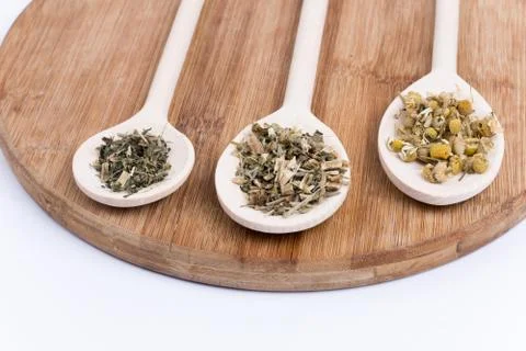 Chamomile tea nettle and basil on a wooden spoon Stock Photos
