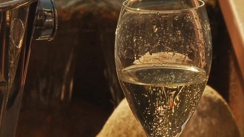 Champagne being poured into a half full glass during daytime Stock Footage 112708772