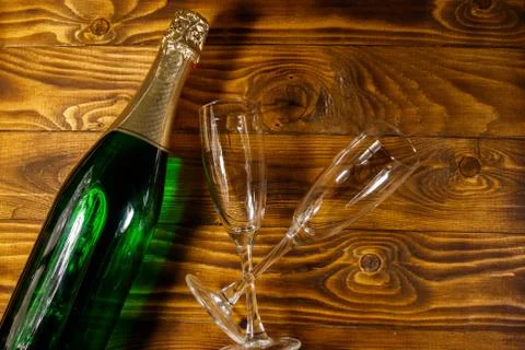 Champagne bottle and two empty champagne glasses on wooden background Stock Photos