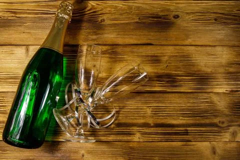 Champagne bottle and two empty champagne glasses on wooden background. Top view Stock Photos