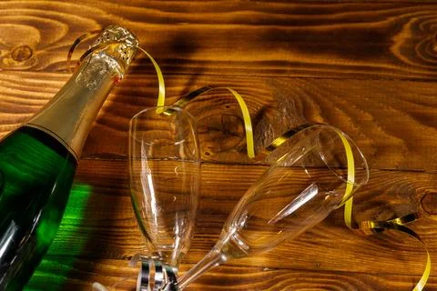 Champagne bottle and two empty champagne glasses on wooden background Stock Photos